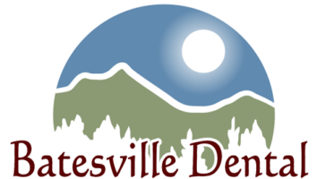 Scenic view of Batesville Main Street at night with illuminated storefronts and mountain backdrop, showcasing the vibrant downtown area of Batesville, Arkansas.