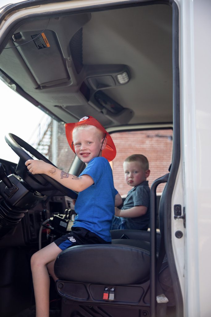 Kids enjoying a fun ride in a fire truck vehicle in Batesville Main Street during a community event.