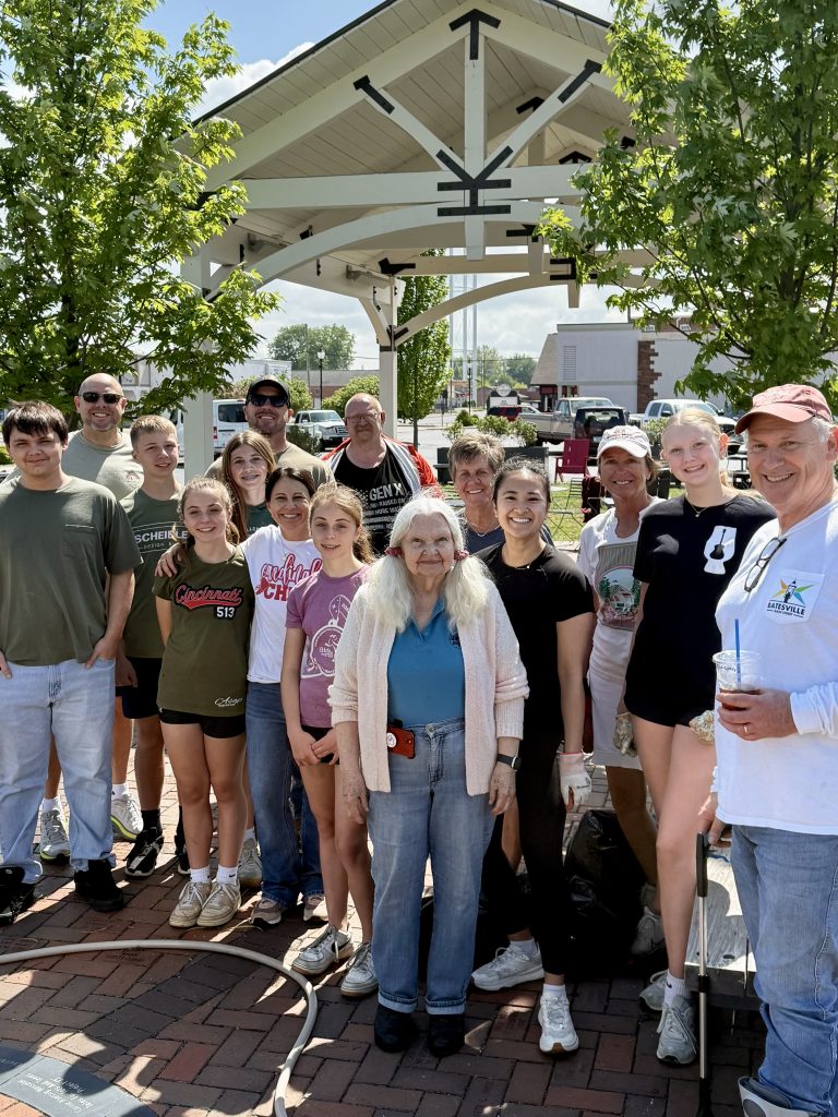 Group of diverse people enjoying a community event on Batesville Main Street under a decorative pavilion, showcasing local engagement and vibrant town life.